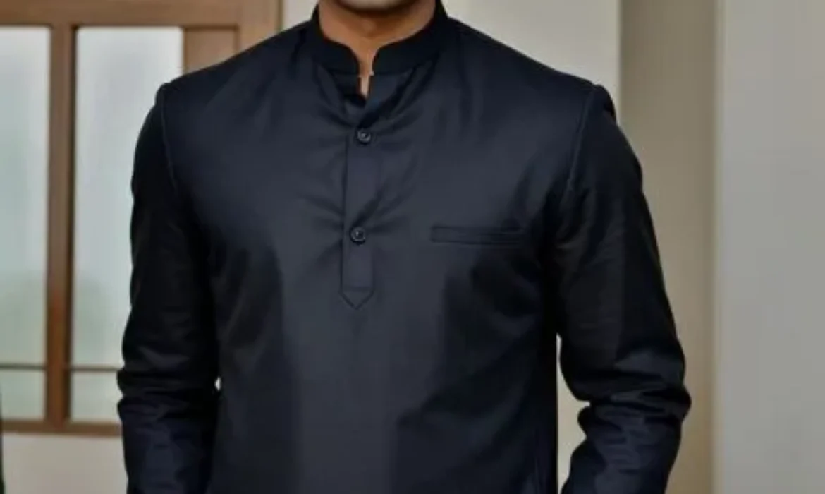 This image depicts a person wearing a dark-colored, long-sleeved shirt. Their face is pixelated to protect their privacy. The individual is standing indoors, with a closed wooden door visible in the background. The shirt appears to be made of a smooth, possibly silky or synthetic fabric.